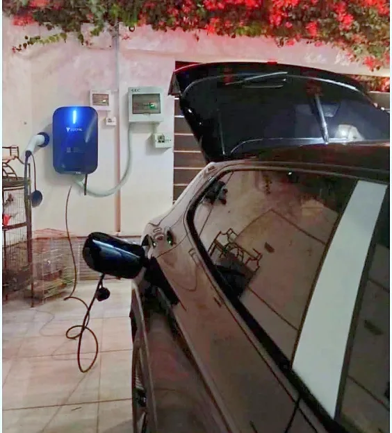 Wall charger and distribution box in the home's car porch, next to the parked car
