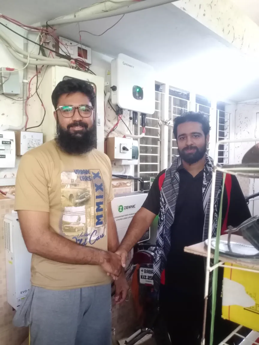 KIE engineer and customer beside a GoodWe inverter, DC breakers and distribution board